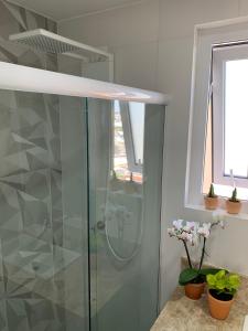 a shower with a glass door in a bathroom at Moderno & Prático Centro in Florianópolis +11 photos
