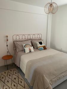 a bedroom with a bed with pillows and a chandelier at Moderno & Prático Centro in Florianópolis