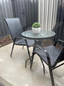 a table and two chairs with a potted plant on it at Central brand new studio in Beechworth +2 photos