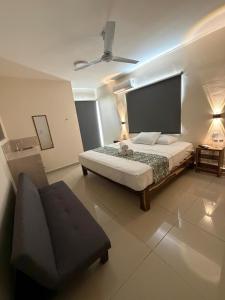 a bedroom with a bed and a couch in it at Hotel Urban Tacana in Tapachula