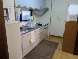 a small kitchen with a sink and a microwave at 一棟貸の宿さくらんぼ in Kami-yuge +14 photos