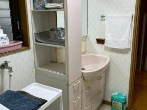 a small bathroom with a sink and a mirror at 一棟貸の宿さくらんぼ in Kami-yuge