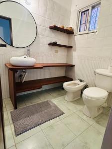 a bathroom with a toilet and a sink and a mirror at Villa del Sol #1 in La Laguna