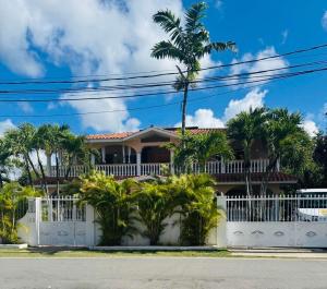 a house with a white fence and palm trees at Villa del Sol #1 in La Laguna