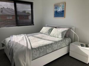 a white bedroom with a bed and a window at George Town Central Apartment in George Town