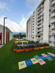 a large apartment building with a lawn with the words exit at Oasis Villeta Apartamento in Villeta