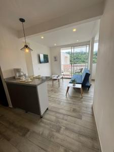a kitchen and living room with a couch and a table at Oasis Villeta Apartamento in Villeta