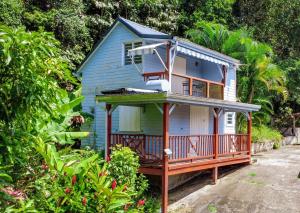 a blue house with a porch and a balcony at Gite de Paulo la source in Pointe-Noire