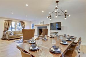 a dining room with a table and a living room at Slopeside Chalet on River Next To WP Resort I Fantastic Views I Private Hot Tub I Gas Firepit I Game Room I Activity Program in Winter Park