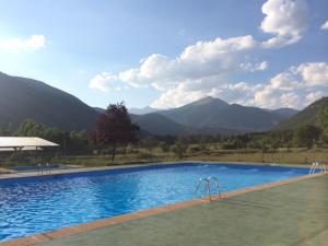 una piscina con montañas en el fondo en Pinarillos, en Sarvisé