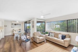 a living room with a couch and chairs and a table at Sunset Reset in Soldiers Point