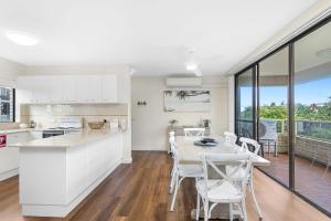 a kitchen and dining room with a table and chairs at Sunset Reset in Soldiers Point