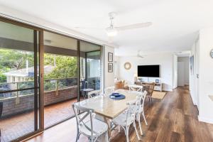 a dining room and living room with a table and chairs at Sunset Reset in Soldiers Point