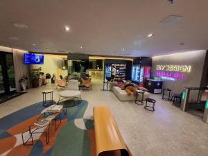 a lobby with a couch and chairs in a store at SKY design Alphaville by Rhouses in Barueri