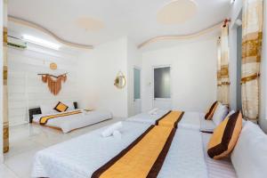 two beds in a room with white walls at Homestay 30 Võ Thị Sáu in Vung Tau