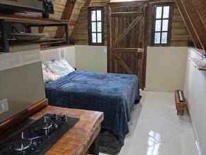 a kitchen with a bed and a stove in a room at Chalés FRONT LAKE 1 in Córrego do Bom Jesus