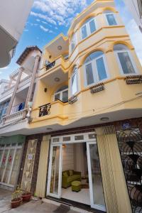 a large yellow building with windows and doors at Homestay 30 Võ Thị Sáu in Vung Tau