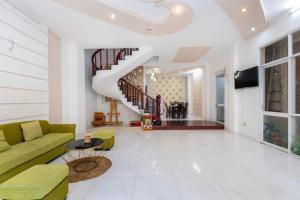 a living room with a green couch and a staircase at Homestay 30 Võ Thị Sáu in Vung Tau