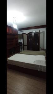 a bedroom with a bed and a dresser in it at Casa Quarto 3 in Jaraguá do Sul
