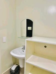 a white bathroom with a sink and a mirror at Ilo2stayAirbnb 1BR 334 in Molo +11 photos