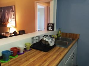 a kitchen counter with a sink and cups on a wooden floor at Downtown 1 Bedroom Apartment 18H in Atlanta