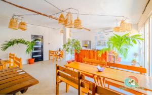 a dining room with wooden benches and potted plants at Playa de la Fuente in El Paredón Buena Vista