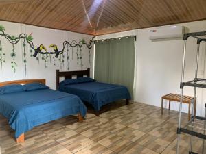 a room with two beds in a room at Hospedaje las rocas in Puerto Jiménez