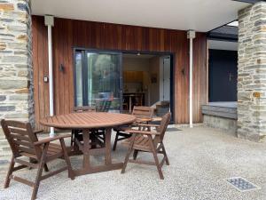 a wooden table and chairs on a patio at Secluded coastal comfort in Dunedin