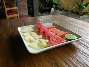 un piatto di frutta su un tavolo di legno di Tara House ad Ubud Altre 20 foto