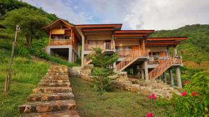 a house on a hill with a stone wall at Saluvi Hill's in Pulau Sarang
