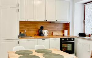 a kitchen with white cabinets and a table with chairs at Tiana in Vrsar
