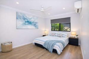a white bedroom with a bed and a window at Golfside Haven 2 Bedroom Duplex with Golf Course in Rosslea