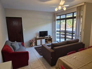 a living room with a couch and a tv at Apto a 3 quadras do centro, 2 quartos lazer comp in Serra Negra