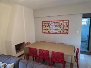 a dining room with a table and red chairs at Apto a 3 quadras do centro, 2 quartos lazer comp in Serra Negra