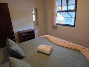 a towel sitting on top of a bed in a bedroom at Apto a 3 quadras do centro, 2 quartos lazer comp in Serra Negra +23 photos