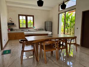 a kitchen with a wooden table and some chairs at Agusta Lake View Bedugul in Pabean Buleleng