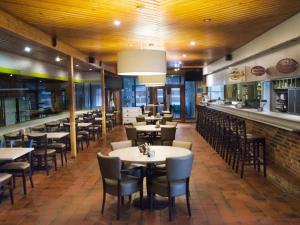 a restaurant with tables and chairs and a bar at Mobile home Keiheuvel 6p in Balen