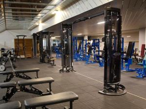 a gym with rows of exercise equipment and machines at Mobile home Keiheuvel 6p in Balen