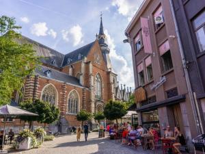 a group of people sitting at tables in front of a church at City apartment with terrace in Hasselt +8 photos