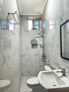 a white bathroom with a sink and a toilet at Al-mendhiry Apartment in Zanzibar City +26 photos