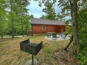 a cabin in the woods with a grill in front of it at Pluggy's Place - Perfect Location - Outdoor Fire pit in Beattyville +36 photos