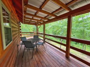 a screened porch with a table and chairs on it at Pluggy's Place - Perfect Location - Outdoor Fire pit in Beattyville