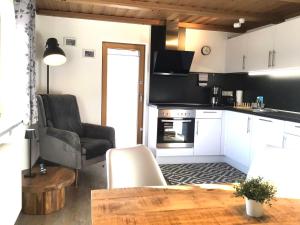 a kitchen with a table and a chair in a room at Ferienwohnung Lederhose in Bischofswiesen