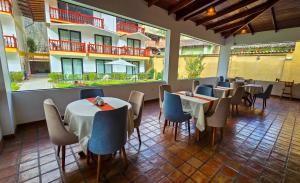 a restaurant with tables and chairs and a building at Tikawasi Ollanta 2 in Ollantaytambo
