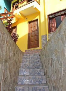 una escalera de piedra que conduce a una casa con puerta marrón en Casa da Val, en Morro de São Paulo