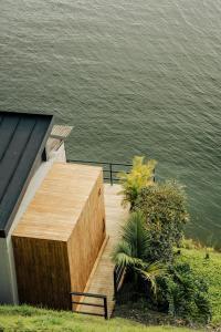 瓜塔佩La Pausa Hotelbistro的水体旁的木制平台