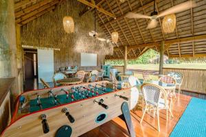 a game room with a foosball table and chairs at Vai Iti Lodge in Afaahiti