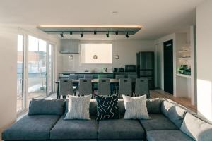 a living room with a blue couch and a kitchen at Grandeur Biei in Biei