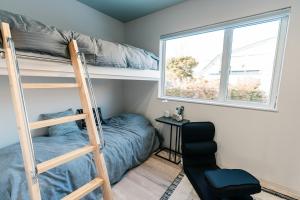 a bedroom with a bunk bed and a chair at Grandeur Biei in Biei