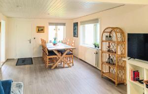a dining room with a table and chairs and a television at 1 Bedroom Nice Home In Hurup Thy in Ullerup